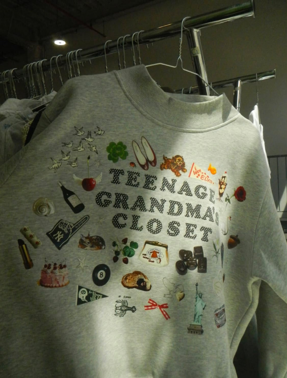 A gray sweatshirt covered in the Teenage Grandma's Closet collage of hand-drawn icons